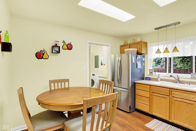 4125 S Post Rd, Indianapolis, IN 46239 - kitchen with freestanding refrigerator, a sink, washer / clothes dryer, electric panel, and light wood-style floors