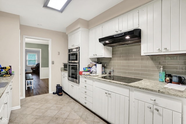 8301 E County Road 801 S, Plainfield, IN 46168 - kitchen with under cabinet range hood, black electric stovetop, tasteful backsplash, white cabinetry, and stainless steel double oven