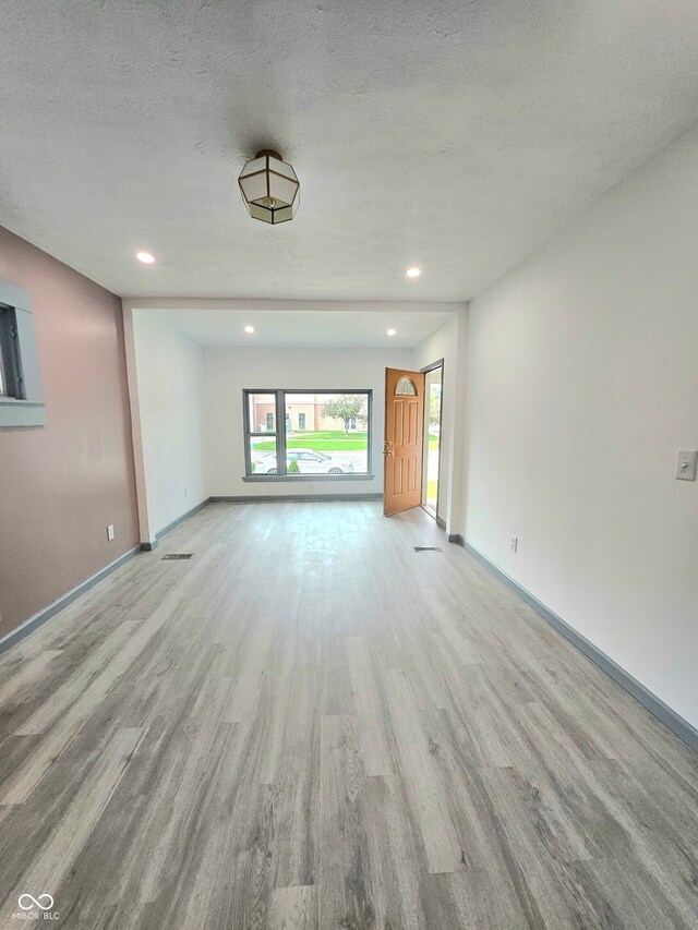 1644 Dr Andrew J Brown Ave, Indianapolis, IN 46202 - unfurnished living room featuring wood finished floors, baseboards, recessed lighting, and a textured ceiling