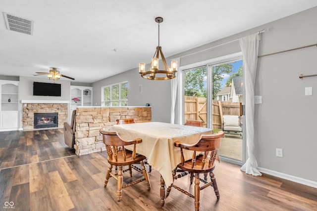 9754 Bradford Knoll Dr, Fishers, IN 46037 - dining space featuring wood finished floors, a stone fireplace, a chandelier, baseboards, and built in features