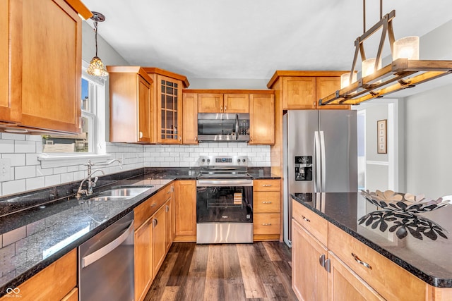 9754 Bradford Knoll Dr, Fishers, IN 46037 - kitchen with stainless steel appliances, a sink, dark wood-type flooring, decorative backsplash, and glass insert cabinets