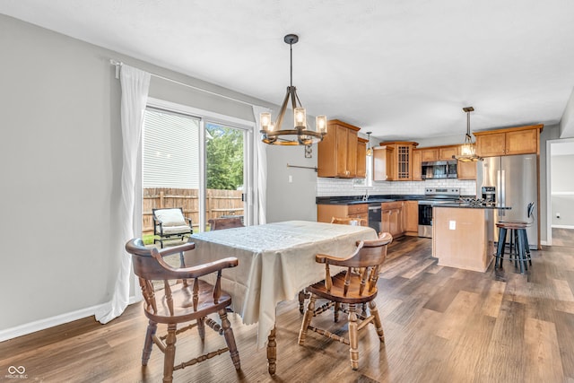 9754 Bradford Knoll Dr, Fishers, IN 46037 - dining area with a chandelier, dark wood-style floors, and baseboards