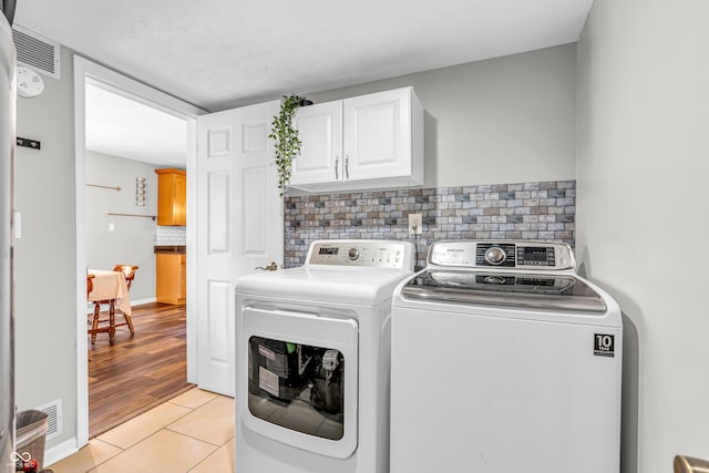 9754 Bradford Knoll Dr, Fishers, IN 46037 - laundry room featuring cabinet space, washer and clothes dryer, and light tile patterned floors