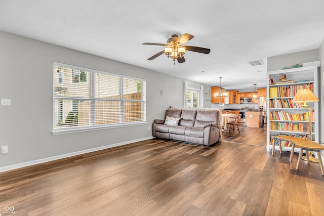 9754 Bradford Knoll Dr, Fishers, IN 46037 - living room with a chandelier, ceiling fan, dark wood-style flooring, and baseboards