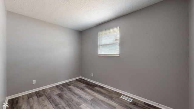 5806 E 19th St, Indianapolis, IN 46218 - empty room with wood finished floors, a textured ceiling, and baseboards
