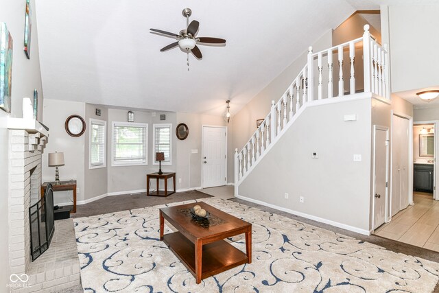 11612 E 75th St, Indianapolis, IN 46236 - living room with lofted ceiling, stairs, a ceiling fan, a brick fireplace, and baseboards