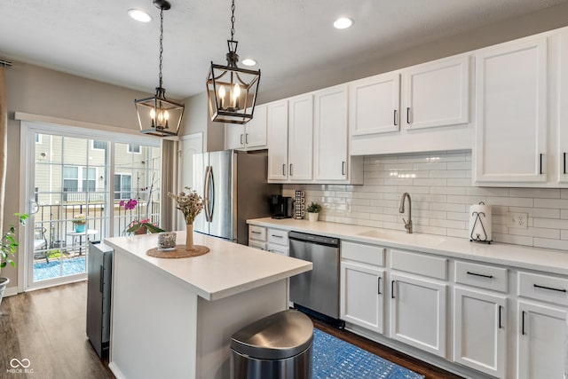9090 Demarest Dr, Fishers, IN 46038 - kitchen with stainless steel appliances, a sink, dark wood-style floors, tasteful backsplash, and white cabinetry