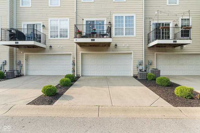 9090 Demarest Dr, Fishers, IN 46038 - rear view of house featuring an attached garage, driveway, and central AC unit