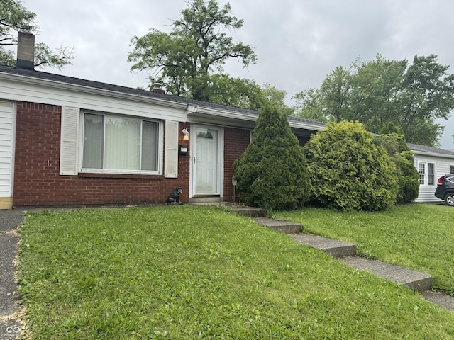 7929 Roy Rd, Indianapolis, IN 46219 - view of front of home featuring brick siding, a front yard, and a chimney