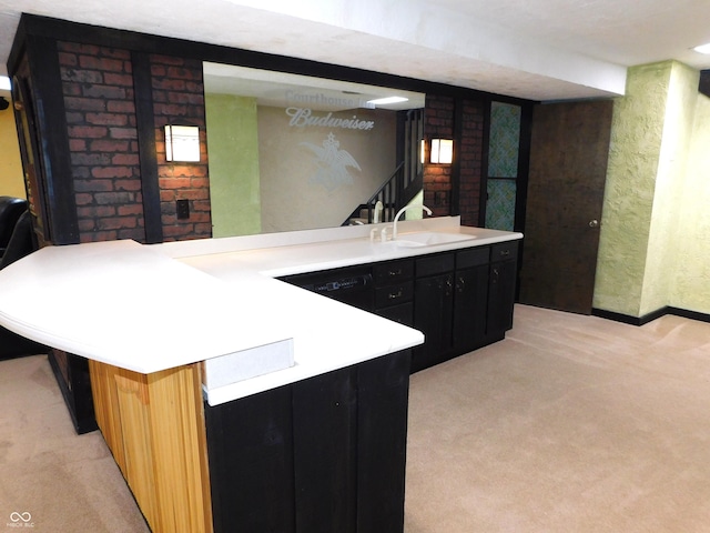 681 S County Road 150 W, Greensburg, IN 47240 - kitchen with light colored carpet, dark cabinetry, a sink, and light countertops