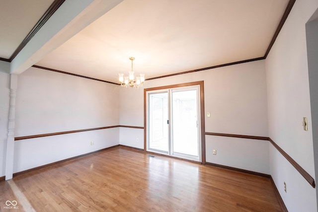 10244 Washington Blvd, Carmel, IN 46280 - empty room with a chandelier, light wood finished floors, ornamental molding, and baseboards