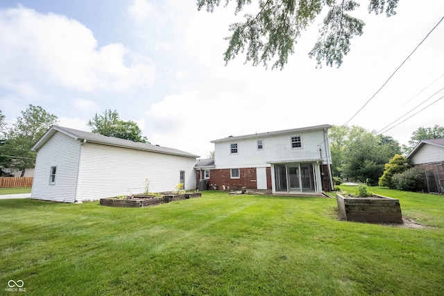 10244 Washington Blvd, Carmel, IN 46280 - back of property featuring a vegetable garden, a sunroom, a lawn, brick siding, and central air condition unit