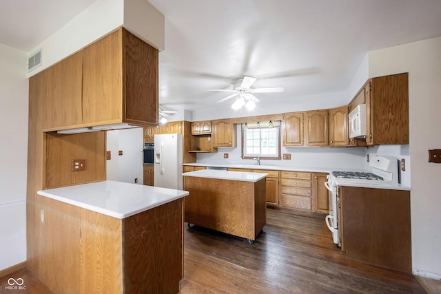 10244 Washington Blvd, Carmel, IN 46280 - kitchen featuring white appliances, a ceiling fan, dark wood finished floors, brown cabinetry, and light countertops