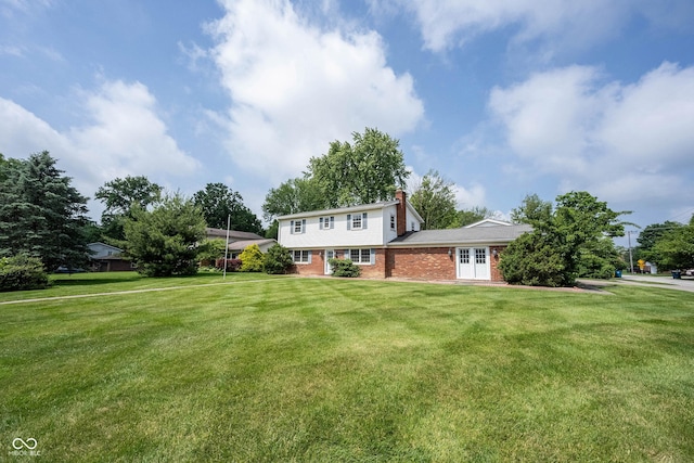 10244 Washington Blvd, Carmel, IN 46280 - view of front of house with brick siding, a chimney, french doors, and a front lawn