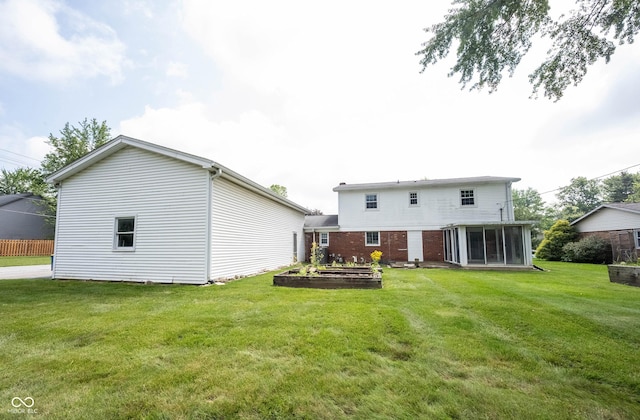 10244 Washington Blvd, Carmel, IN 46280 - back of house with a lawn, a sunroom, and a vegetable garden