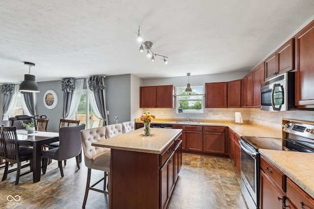 2509 Cedarmill Dr, Franklin, IN 46131 - kitchen with stainless steel appliances, a sink, a kitchen bar, tasteful backsplash, and light countertops
