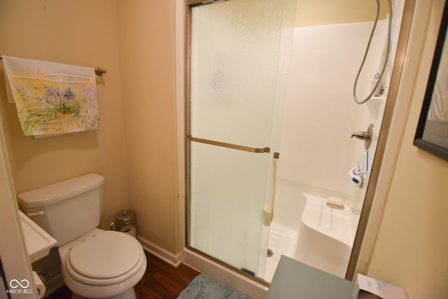 1150 Extraordinary Trl, Greenfield, IN 46140 - bathroom with a stall shower, wood finished floors, toilet, and baseboards