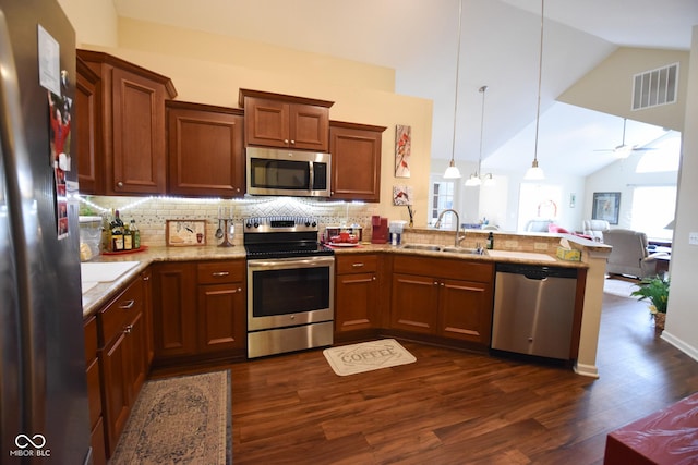 1150 Extraordinary Trl, Greenfield, IN 46140 - kitchen featuring stainless steel appliances, a sink, a peninsula, dark wood-type flooring, and decorative backsplash