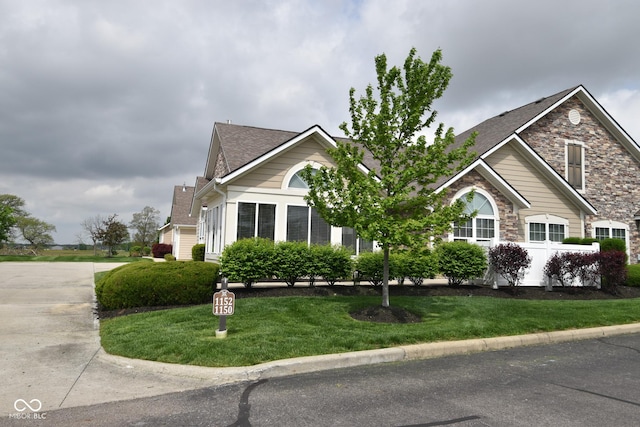 1150 Extraordinary Trl, Greenfield, IN 46140 - view of front of house featuring a front lawn, roof with shingles, and stone siding