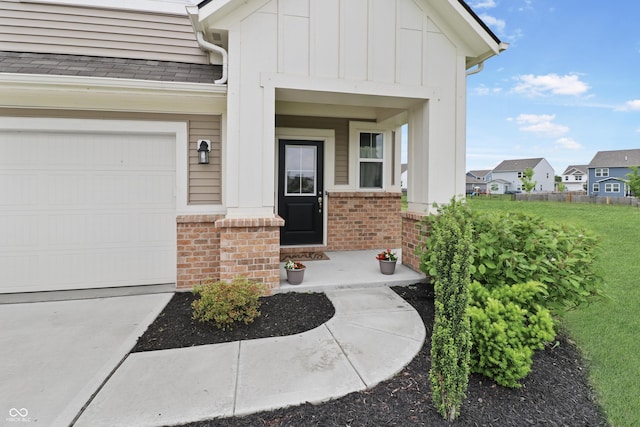 6917 Wolf Creek Ct, Whitestown, IN 46075 - property entrance with board and batten siding, brick siding, a garage, a porch, and concrete driveway