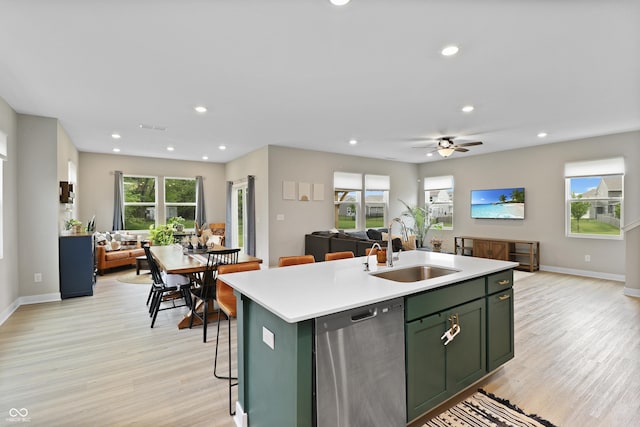 6917 Wolf Creek Ct, Whitestown, IN 46075 - kitchen featuring green cabinetry, dishwasher, a sink, open floor plan, and light wood-style floors