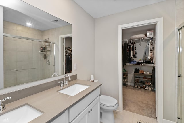 6917 Wolf Creek Ct, Whitestown, IN 46075 - bathroom with double vanity, a walk in closet, toilet, a shower stall, and tile patterned flooring