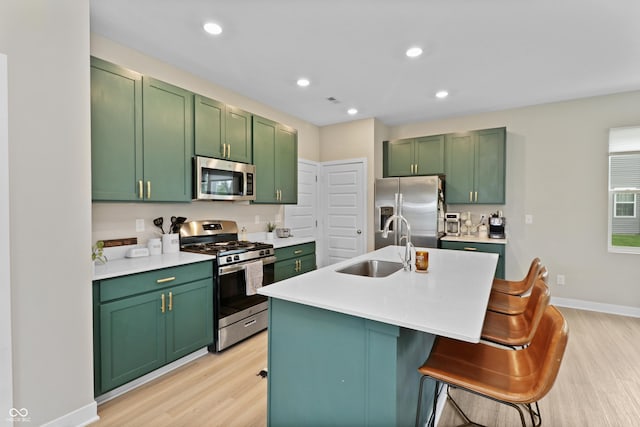 6917 Wolf Creek Ct, Whitestown, IN 46075 - kitchen with stainless steel appliances, green cabinets, a sink, light wood-type flooring, and light countertops
