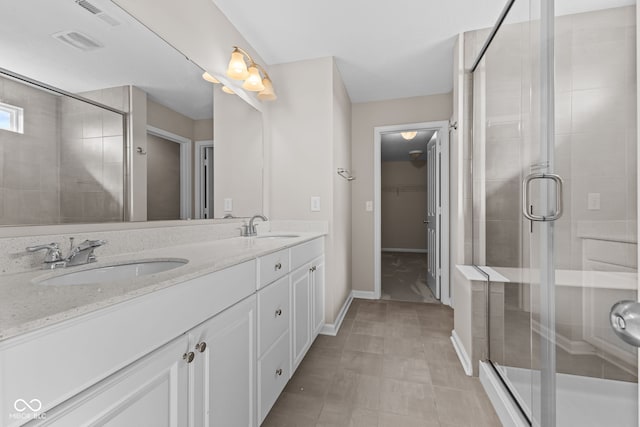 4539 Maldenhair Dr, Indianapolis, IN 46239 - full bathroom with double vanity, a stall shower, a spacious closet, and baseboards