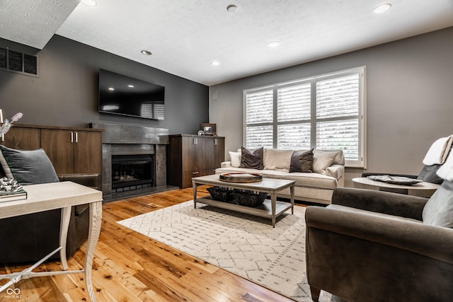 9804 Wentworth Ct, Carmel, IN 46032 - living room with a textured ceiling, light wood-type flooring, a fireplace, and recessed lighting
