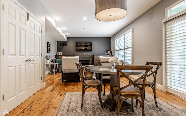 9804 Wentworth Ct, Carmel, IN 46032 - dining area with light wood finished floors, healthy amount of natural light, a fireplace, recessed lighting, and baseboards