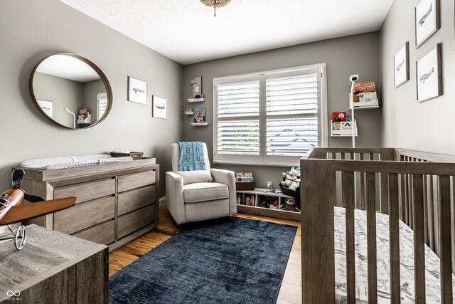 9804 Wentworth Ct, Carmel, IN 46032 - bedroom featuring light wood finished floors and a nursery area