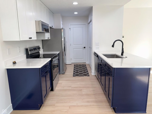 6845 Arjay Dr, Indianapolis, IN 46217 - kitchen featuring electric range oven, a sink, stainless steel microwave, blue cabinets, and recessed lighting