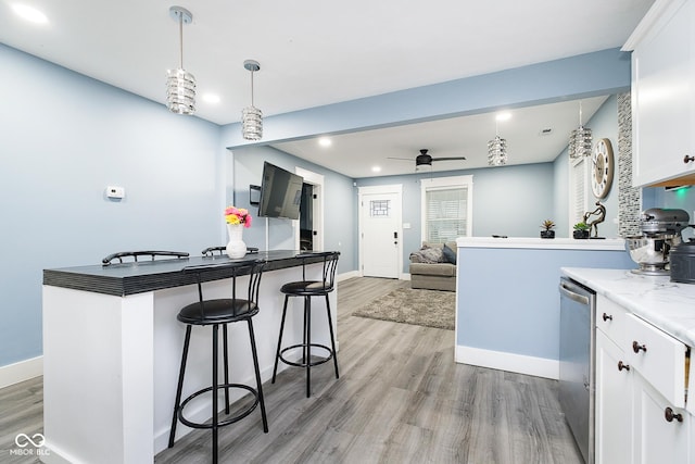 2209 W 9th St, Muncie, IN 47302 - kitchen featuring a kitchen breakfast bar, light wood-style flooring, ceiling fan, white cabinets, and recessed lighting