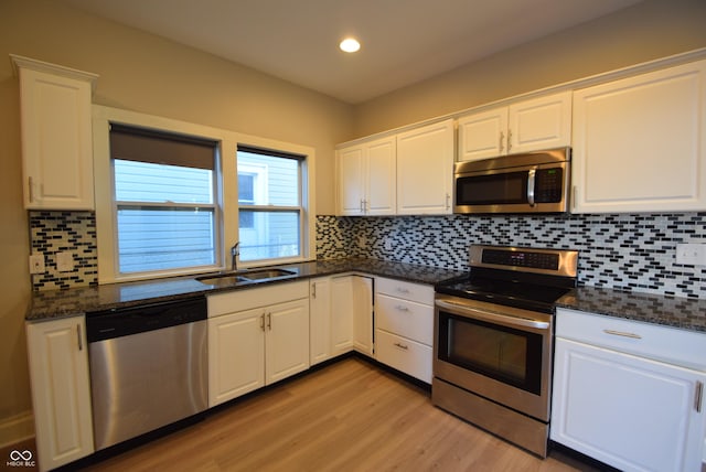 4231 Carrollton Ave, Indianapolis, IN 46205 - kitchen featuring appliances with stainless steel finishes, a sink, light wood-type flooring, recessed lighting, and white cabinets