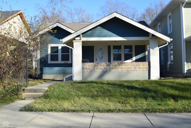 4231 Carrollton Ave, Indianapolis, IN 46205 - view of front of home with covered porch and a front lawn