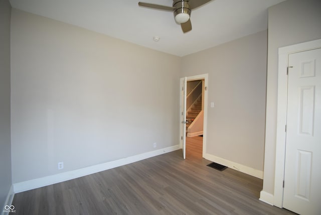 4231 Carrollton Ave, Indianapolis, IN 46205 - unfurnished bedroom with dark wood-style flooring, baseboards, and ceiling fan
