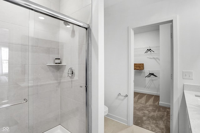 15387 Alperton Rd, Fishers, IN 46037 - bathroom with a stall shower, toilet, a spacious closet, vanity, and baseboards