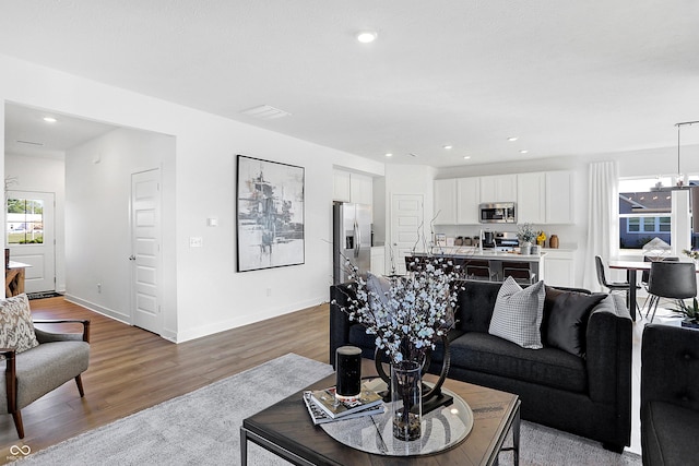15387 Alperton Rd, Fishers, IN 46037 - living area featuring light wood-style flooring, recessed lighting, baseboards, and a chandelier