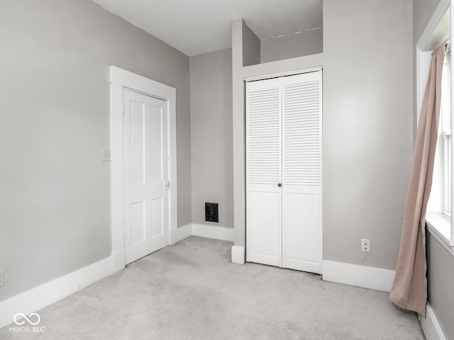 914 English Ave, Indianapolis, IN 46203 - unfurnished bedroom with carpet, a closet, baseboards, and a textured ceiling