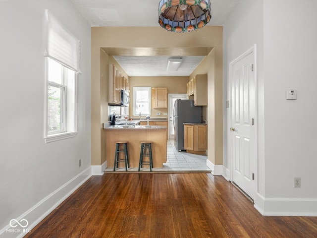 914 English Ave, Indianapolis, IN 46203 - kitchen with a peninsula, wood finished floors, baseboards, and appliances with stainless steel finishes