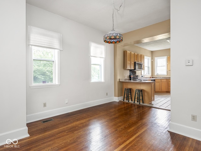 914 English Ave, Indianapolis, IN 46203 - kitchen featuring stainless steel microwave, healthy amount of natural light, and a breakfast bar