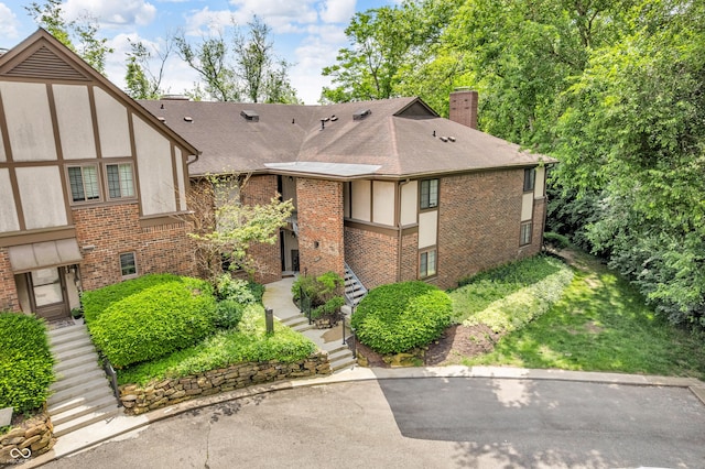 2267 Rome Dr Unit A, Indianapolis, IN 46228 - view of front of home with a chimney, brick siding, roof with shingles, and stucco siding