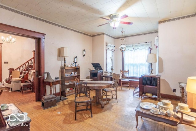 4526 Iowa St, Clayton, IN 46118 - living room with a ceiling fan, light wood-type flooring, ornamental molding, and a chandelier