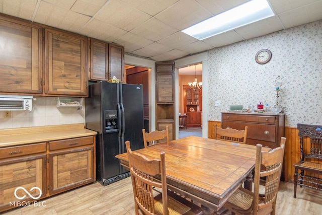 4526 Iowa St, Clayton, IN 46118 - dining area with a chandelier, wallpapered walls, and light wood-type flooring