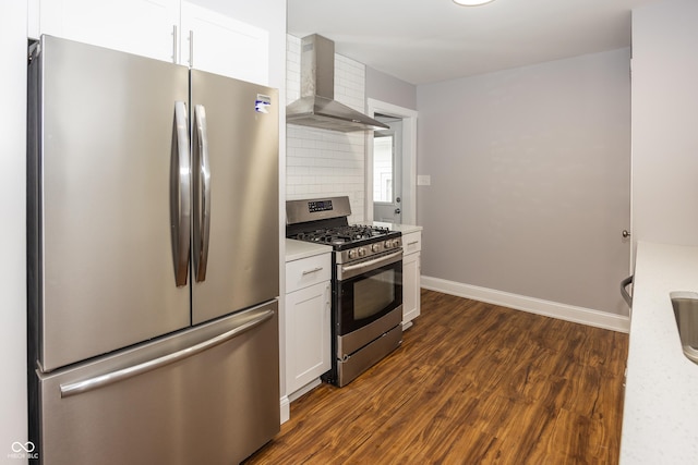 4933 W 13th St W, Speedway, IN 46224 - kitchen with stainless steel appliances, wall chimney range hood, dark wood-type flooring, white cabinetry, and light countertops