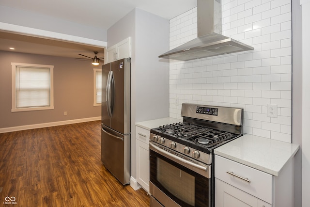 4933 W 13th St W, Speedway, IN 46224 - kitchen featuring wall chimney range hood, appliances with stainless steel finishes, backsplash, white cabinets, and dark wood finished floors