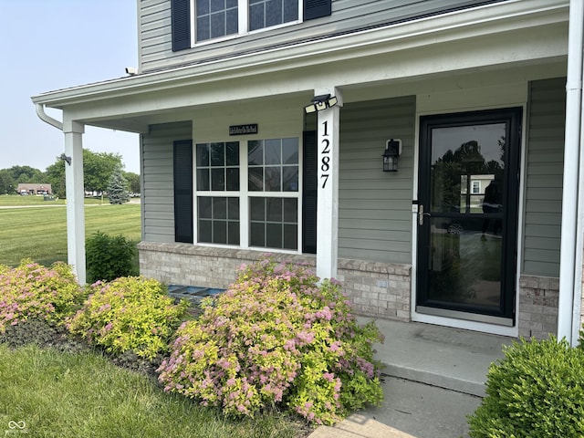 1287 Highland Lake Way, Brownsburg, IN 46112 - property entrance featuring covered porch, brick siding, and a yard