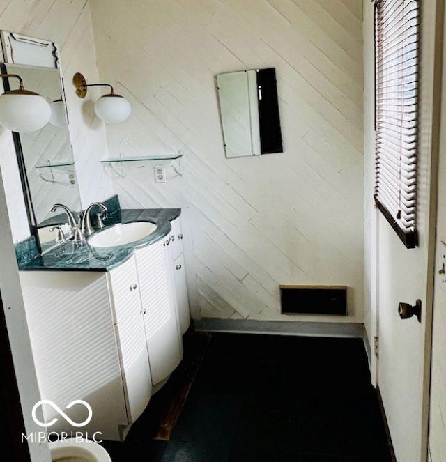 3824 Forest Ridge Dr, Fort Wayne, IN 46804 - bathroom featuring vanity, wood walls, and wood finished floors