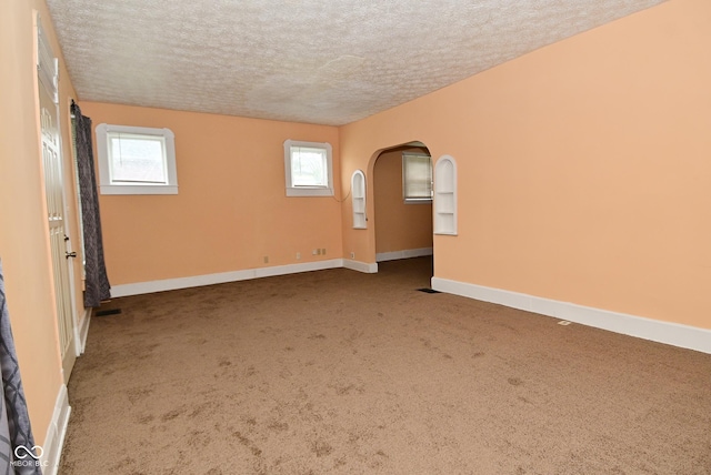 2622 Ethel Ave, Indianapolis, IN 46208 - spare room featuring a textured ceiling, carpet floors, baseboards, and arched walkways