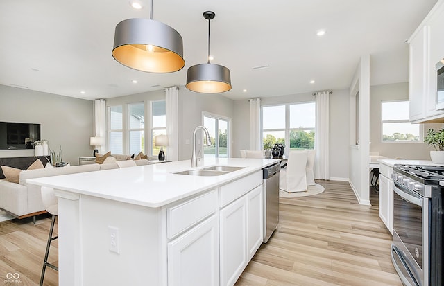 600 Dalton Way, Avon, IN 46123 - kitchen with appliances with stainless steel finishes, a sink, open floor plan, light wood-type flooring, and light countertops